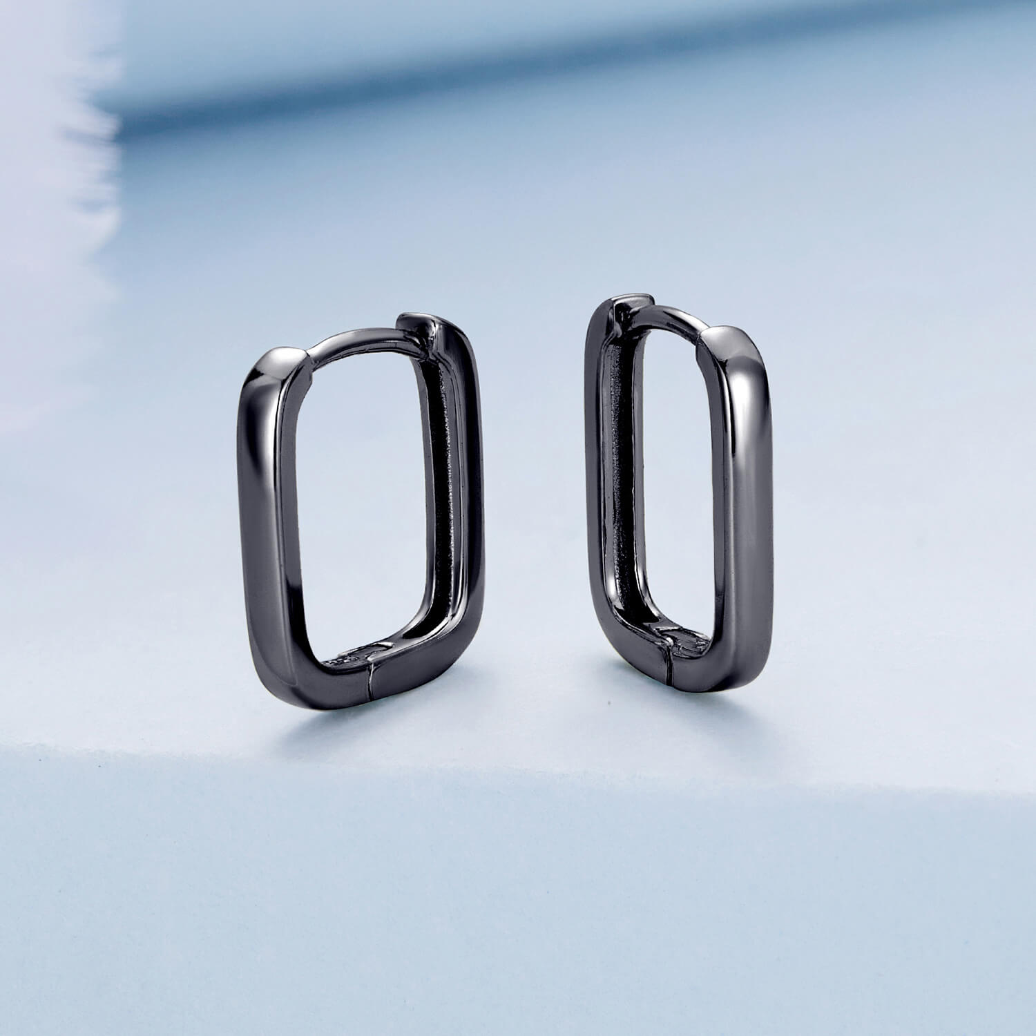 Black Ovate Huggie Earrings in Sterling Silver front