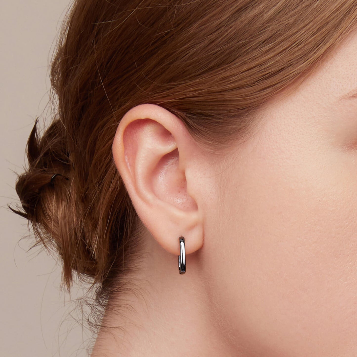 Black Ovate Huggie Earrings in Sterling Silver model